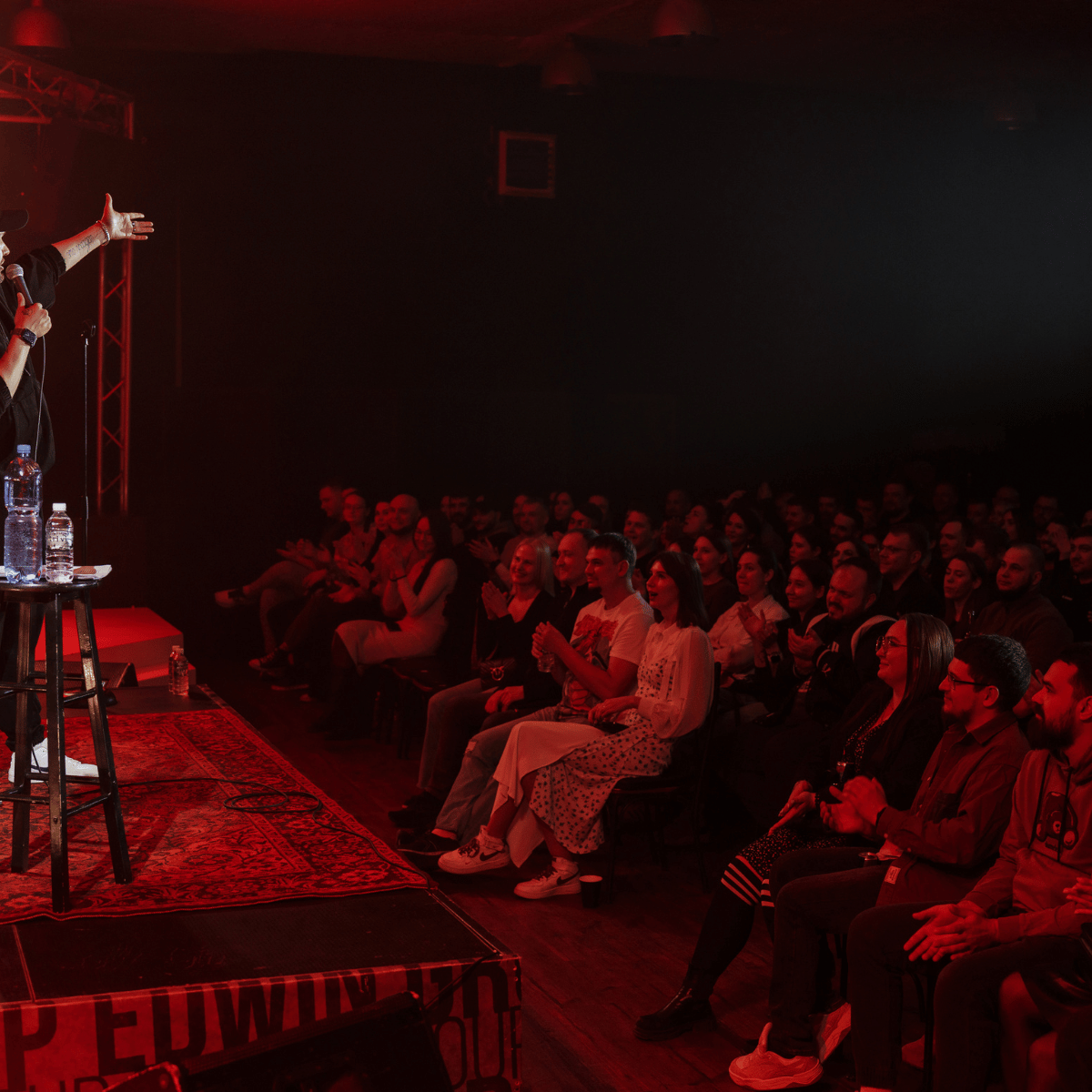 Sala premium con iluminación roja para shows de stand-up
